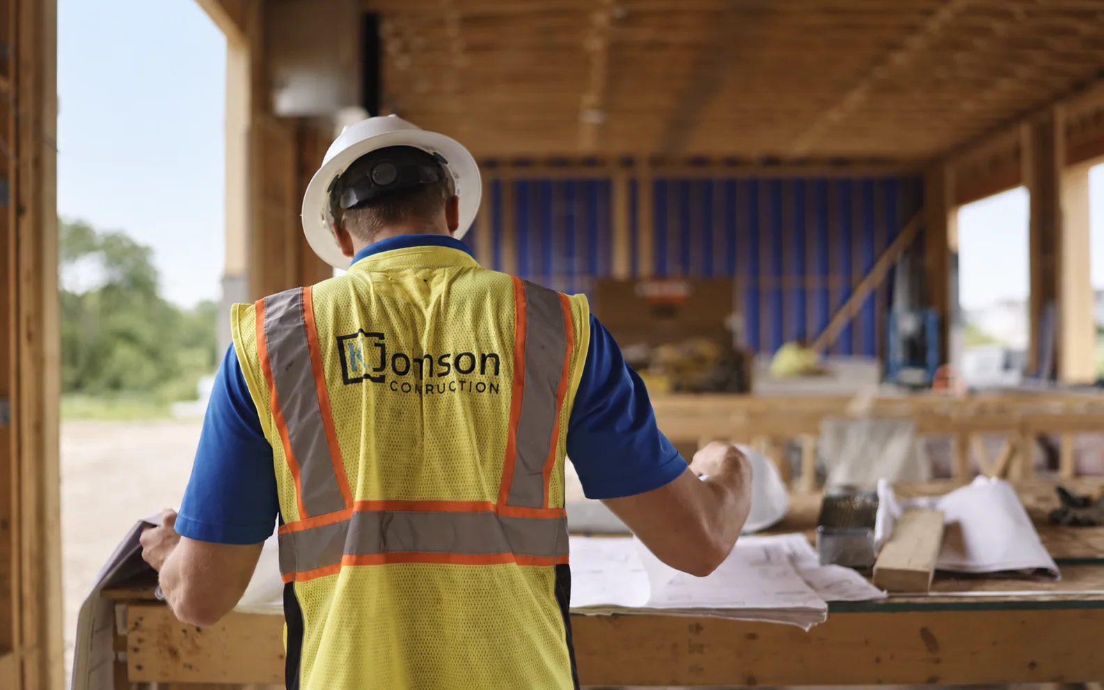 K. Johnson Construction team member reviewing plans on an active construction site